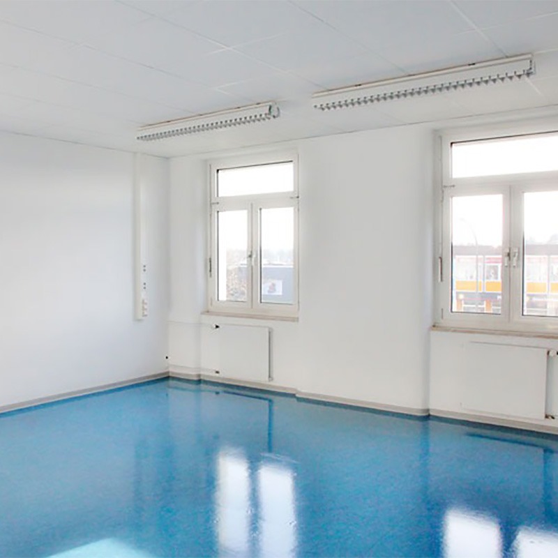 Ein leerer heller Raum mit weißen Wändern und blauem glatten Boden.